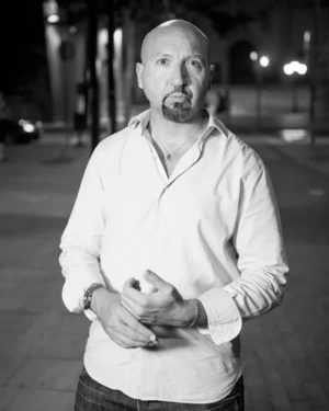Colin Morgan posing on a night street with white shirt - Black and white male portrait.