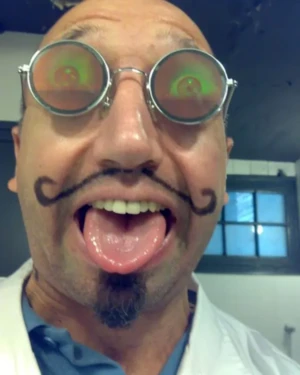 Colin Morgan with visual effect round glasses and painted mustache - Fun selfie on set.